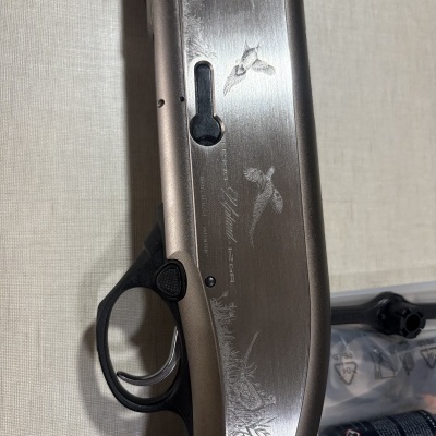 Parte de uma arma de fogo Beretta A391 Urika calibre 12 GA com gravação decorativa de patos em voo.