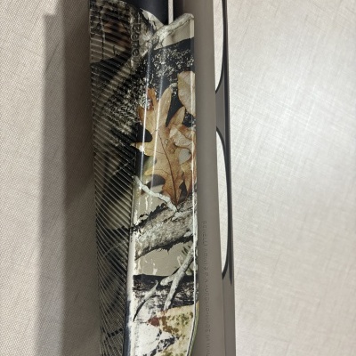 Parte de espingarda camuflada com texto Benelli Armi S.P.A. Urbino Made in Italy