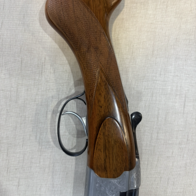 Coronha de madeira castanha de espingarda com corpo metálico gravado e gatilho preto