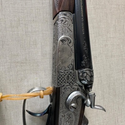 Espingarda de caça com gravações ornamentais e cabo de madeira castanha