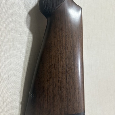 Coronha de madeira castanha escura com relevo preto na parte superior