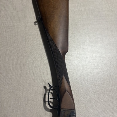 Espingarda de cano duplo com coronha em madeira castanha e borracha vermelha