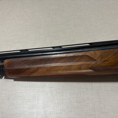 Parte de espingarda com madeira trabalhada e cano preto