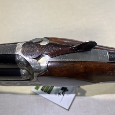 Espingarda dupla com madeira escura e metal prateado