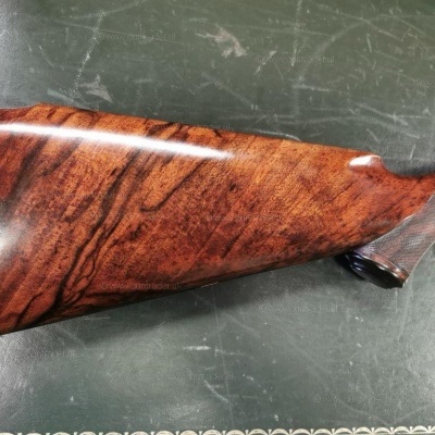 Coronha de espingarda em madeira polida castanha sobre superfície verde