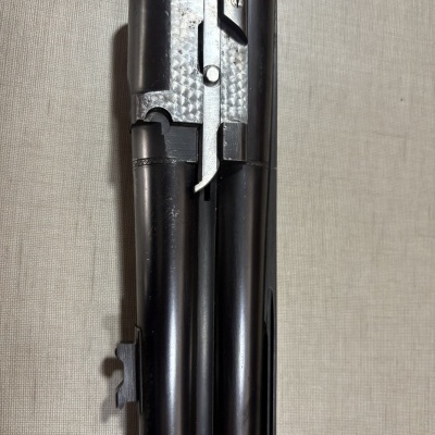 Parte frontal de duas câmaras de espingarda em metal negro e prata martelada