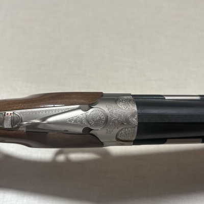 Espingarda de cano duplo com madeira escura e metal gravado