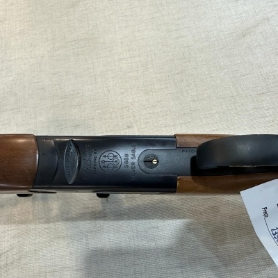 Arma de caça em madeira e metal com etiqueta branca