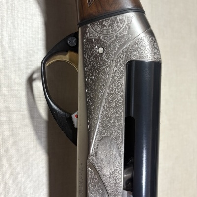 Parte lateral de espingarda com punho de madeira e metal gravado