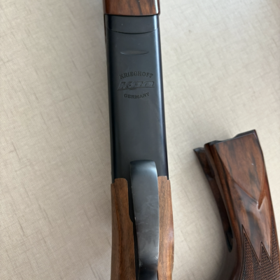 Arma de fogo com madeira e metal preto sobre superfície branca