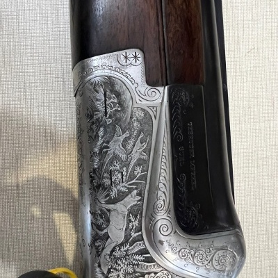 Espingarda com acabamento metálico gravado e coronha em madeira escura