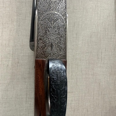 Arma de fogo com gravações florais em metal e madeira castanha