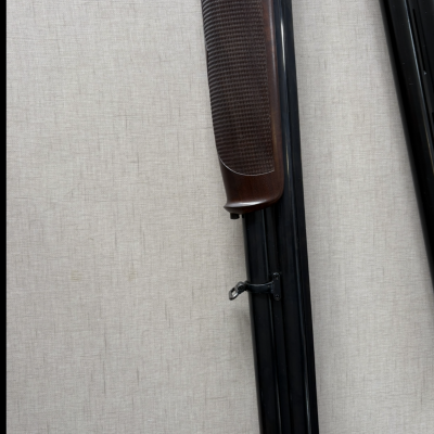 Arma de caça com coronha em madeira castanha escura e barra metálica preta