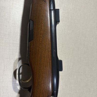 Espingarda com madeira castanha e metal preto com inscrição Steyr Mannlicher Luxus.