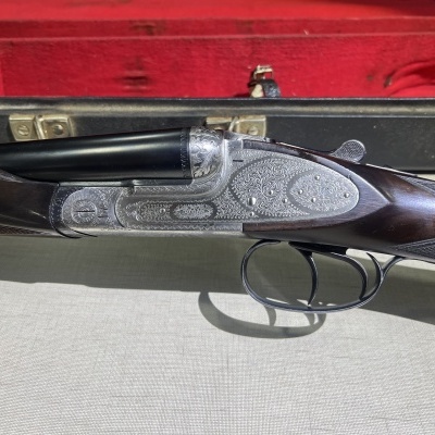 Espingarda de canos duplos com gravações em metal e coronha em madeira escura