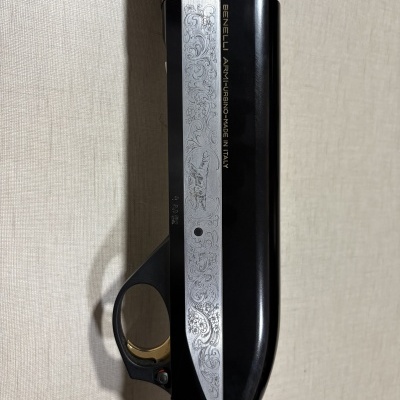 Parte de espingarda Benelli com gravações florais em metal preto e prata e madeira escura