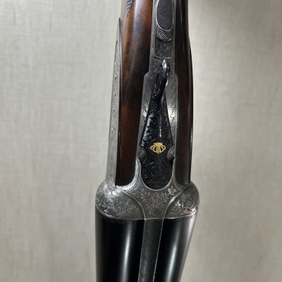 Escopeta de canos duplos com acabamento em madeira e metal gravado