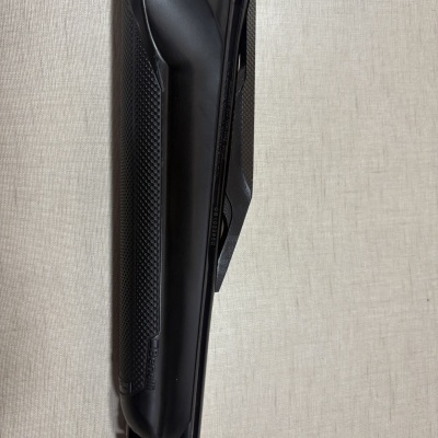 Parte frontal de uma arma Benelli preta com detalhes texturizados