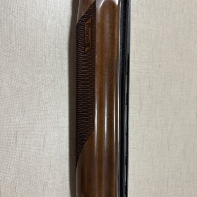 Parte de espingarda Benelli com cabo de madeira castanha e cano metálico preto