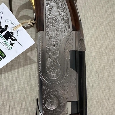 Parte lateral de espingarda em madeira e metal gravado com etiqueta pendurada