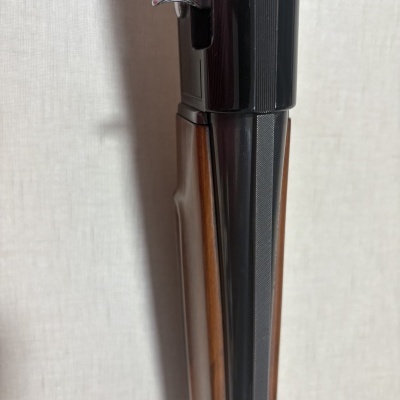 Imagem de parte de arma de fogo com madeira e metal preto