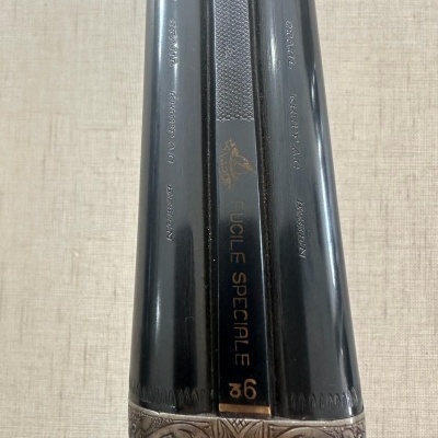 Espingarda com canos duplos pretos e detalhes gravados em metal prateado