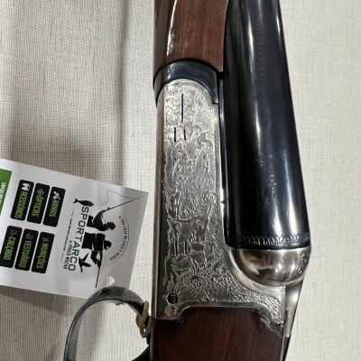 espingarda de canos duplos com gravuras e empunhadura de madeira