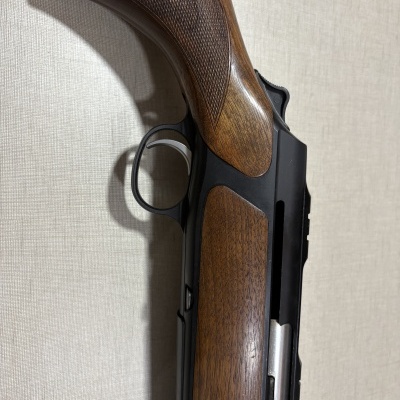 Cabo e gatilho de arma de fogo com madeira castanha e metal preto