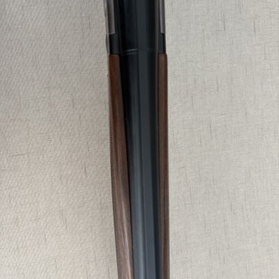 Parte superior de arma de fogo com madeira castanha e metal preto