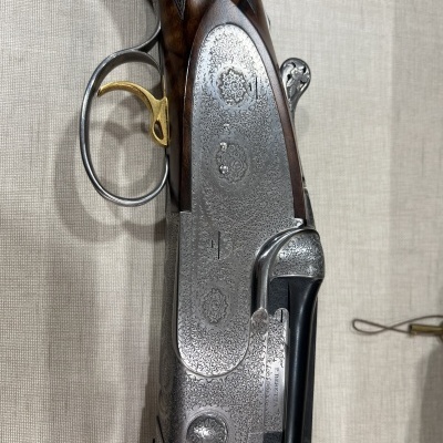 Espingarda de caça com detalhes em madeira e metal gravado