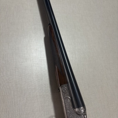 Espingarda de caça em metal negro e madeira com gravações decorativas