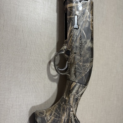Espingarda de caça camuflada preta, cinza e bege com padrão de ramos