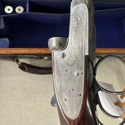 Espingarda de caça com coronha em madeira escura e metais gravados em estojo de madeira