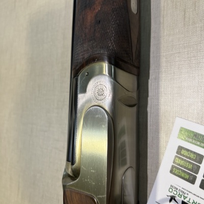 Detalhe de espingarda em madeira e metal com documento ao lado