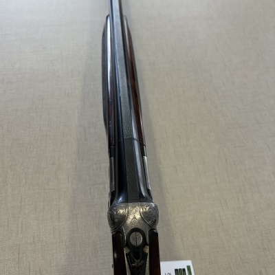 Espingarda de cano duplo com acabamento metálico e coronha em madeira escura