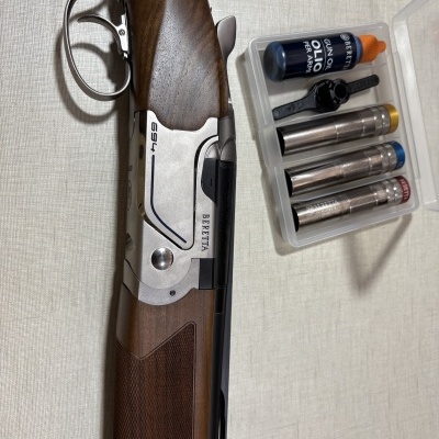 Espingarda Beretta com estojo e acessórios para manutenção.