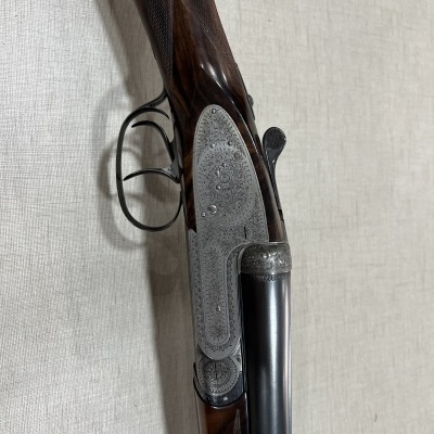 Rifle de caça de canos duplos em madeira e metálico com detalhes gravados