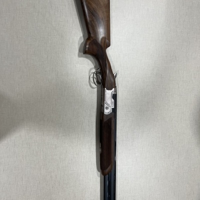 Espingarda de cano duplo com coronha em madeira escura e metal prateado