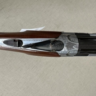 Espingarda de canos duplos com cabo de madeira castanha e detalhes em metal gravado