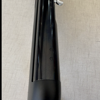 Parte superior de uma espingarda preta com seletor prateado