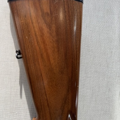 Coronha de madeira polida com detalhe preto pendurada na parede