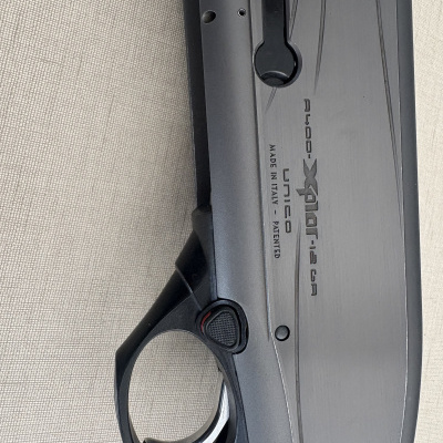 Parte de arma de fogo preta com texto gravado e gatilho cromado