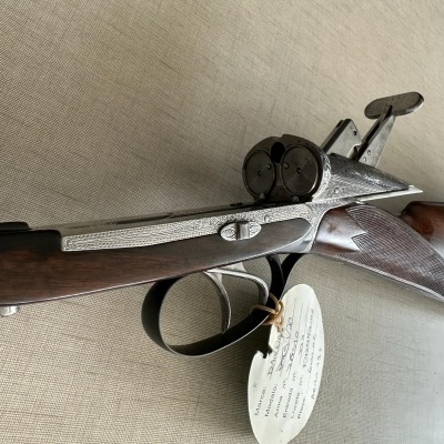 Espingarda de canos duplos em madeira e metal com etiqueta pendurada