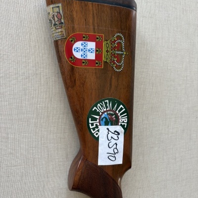 Parte traseira de arma de madeira com autocolantes e etiquetas