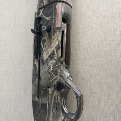 Espingarda camuflada com gatilho metálico em fundo claro