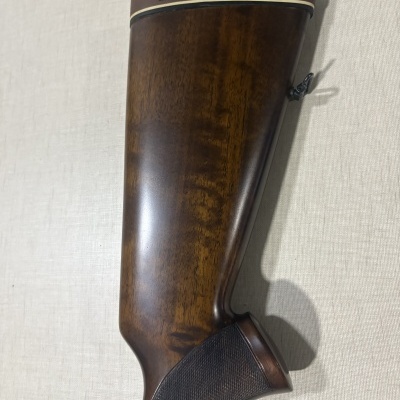 Ponteira de arma de fogo em madeira polida castanha com detalhes texturizados