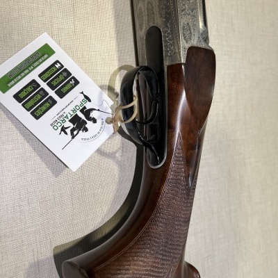 Arma de fogo de cano duplo com coronha de madeira e mecanismo metálico com etiqueta