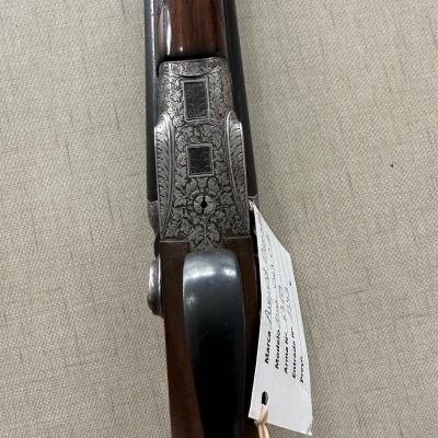 Espingarda decorada com etiqueta branca pendurada sobre tecido bege