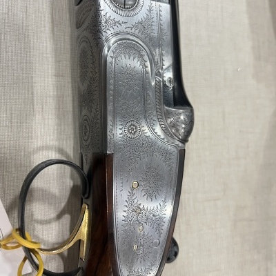 Espingarda com gravações florais em metal prateado e cabo de madeira escura
