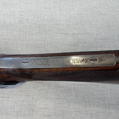 Espingarda com armação metálica e cabo em madeira escura com gravura texto